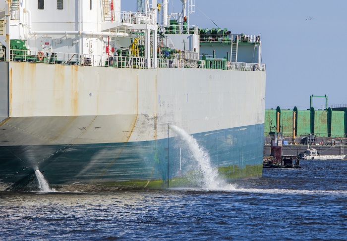 Petrolero descargando lastre en el puerto.  El agua fluye desde el